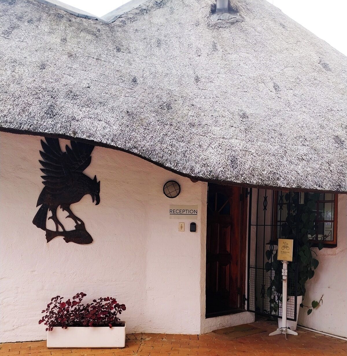 A building with a thatched roof, a reception sign, and a large eagle mural.