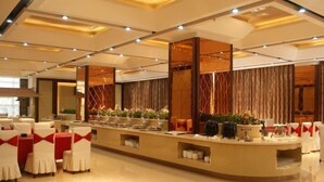 Una hall d'albergo moderna con reception, area relax e piante ornamentali.
