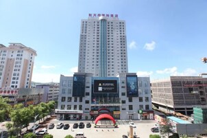 A multi-story building with a prominent entrance and a large digital display.