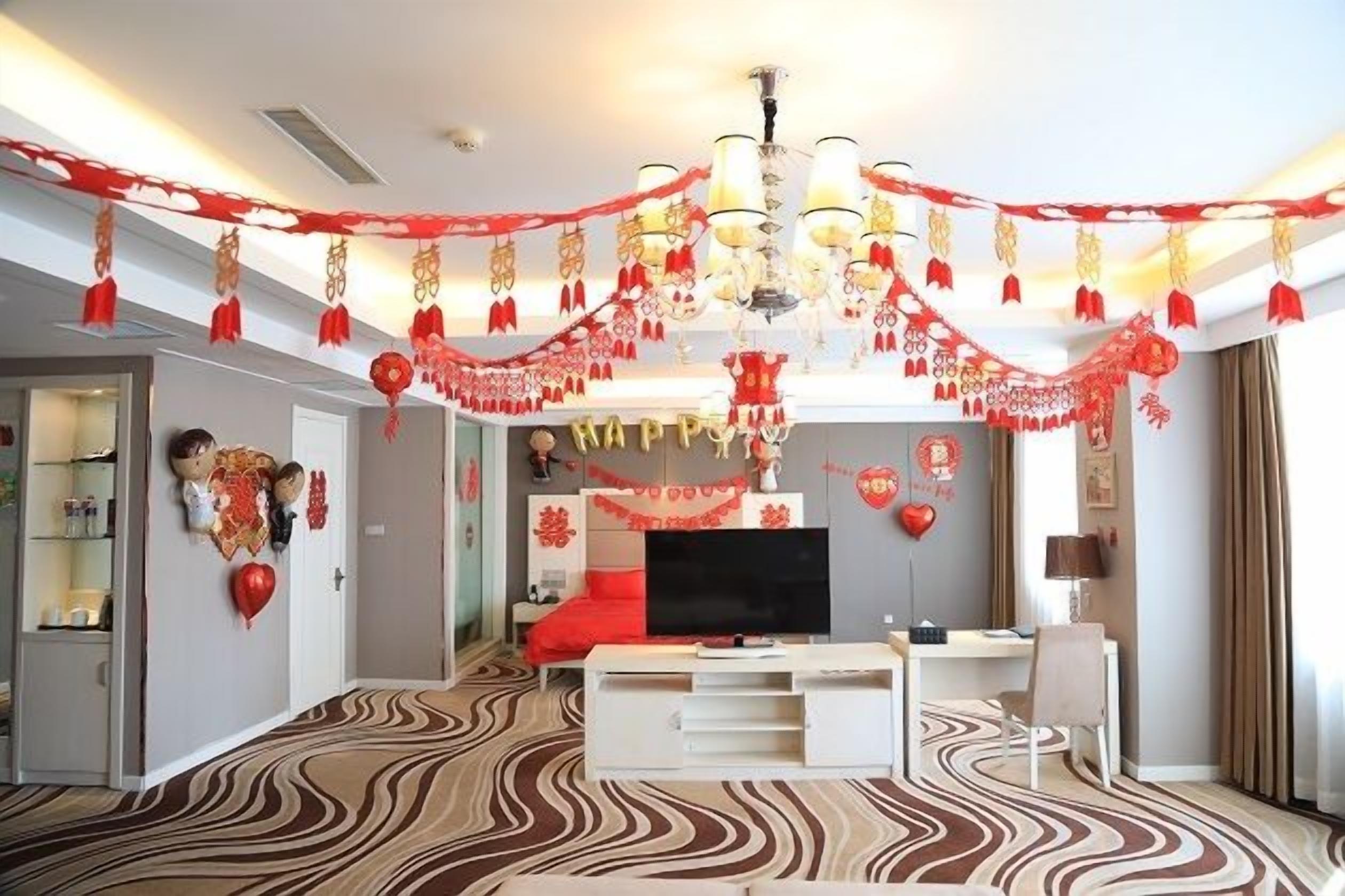 A modern living room with a flat-screen TV, a red sofa, and a patterned carpet.