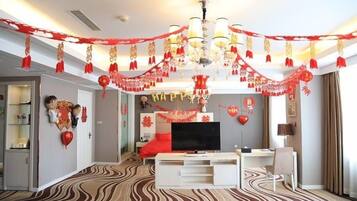 Una sala de estar moderna con un televisor de pantalla plana, un sofá rojo y una alfombra estampada.