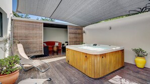 A modern outdoor area with a wooden hot tub, lounge chairs, and potted plants. - La Villa des Mainates - Jacuzzi et vue mer (Le Tampon)