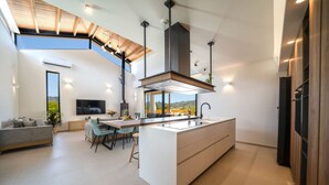 Una cocina moderna con una isla central, electrodomésticos integrados y un comedor con vistas.