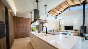 Una cocina moderna con una isla grande, armarios de madera y un tragaluz.
