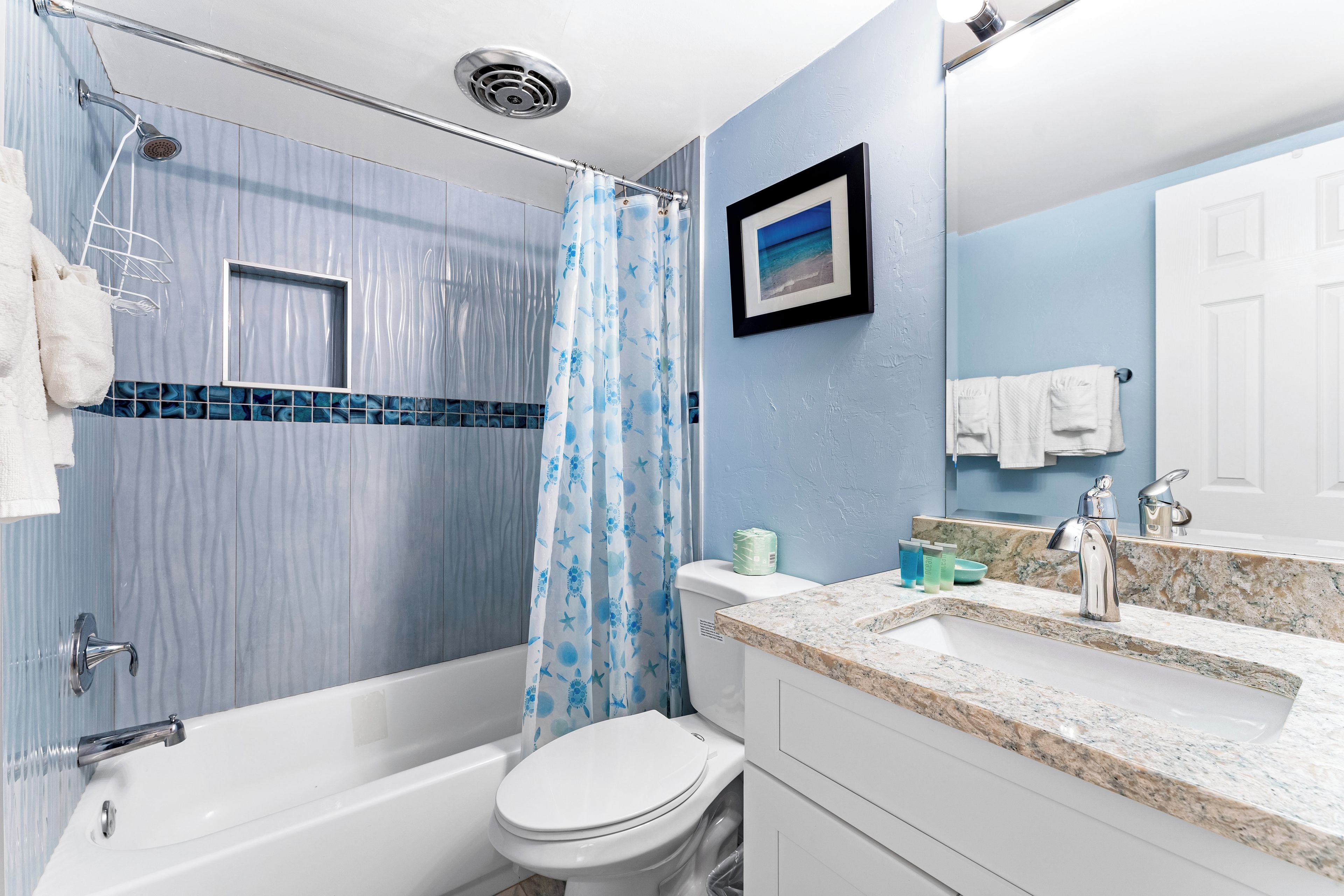 A bathroom with a bathtub, toilet, and shower curtain.