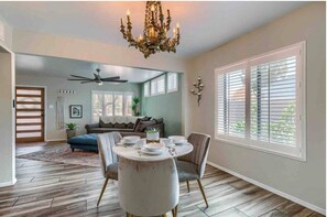 Enjoy meals in this dining area with a round table for four, a chandelier, and a ceiling fan.
