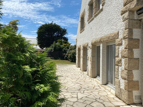 Un bâtiment en pierre avec un chemin pavé menant à l’entrée.