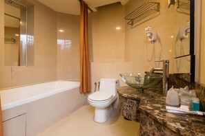 Une salle de bain moderne avec une baignoire, des toilettes et un lavabo en verre.