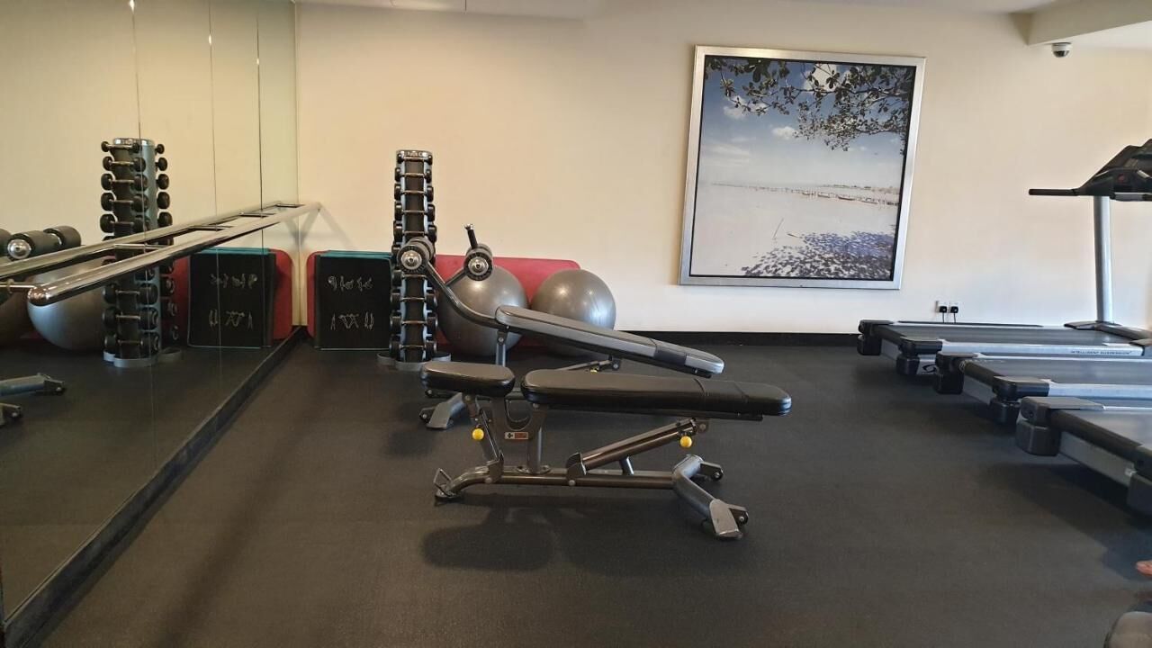 A gym with exercise equipment, a treadmill, and a large framed picture on the wall.