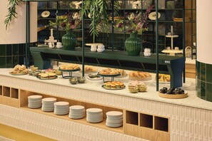 A buffet setup with various food items and a green decorative display. - Van der Valk Hotel Paris CDG Airport (Roissy-en-France)