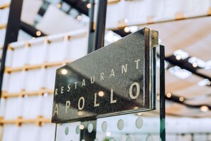 A sign with the text "RESTAURANT APOLLO" in a modern, industrial-style building.