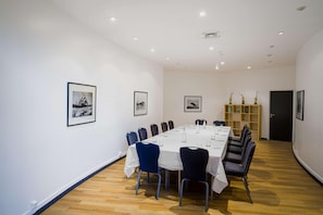 A conference room with a long table, chairs, and framed pictures on the walls. - Van der Valk Hotel Paris CDG Airport (Roissy-en-France)