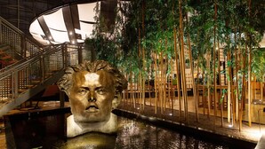 A statue in a water feature with a staircase and bamboo plants in the background. - Van der Valk Hotel Paris CDG Airport (Roissy-en-France)