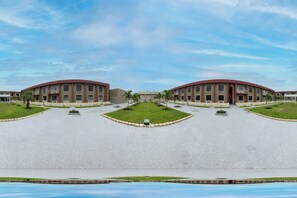 A symmetrical building with a central courtyard, multiple balconies, and a flat roof. - OYO Hotel Orlando Airport (Orlando)