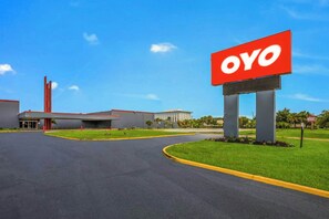 A commercial building with a large OYO sign, a covered entrance, and a parking lot. - OYO Hotel Orlando Airport (Orlando)