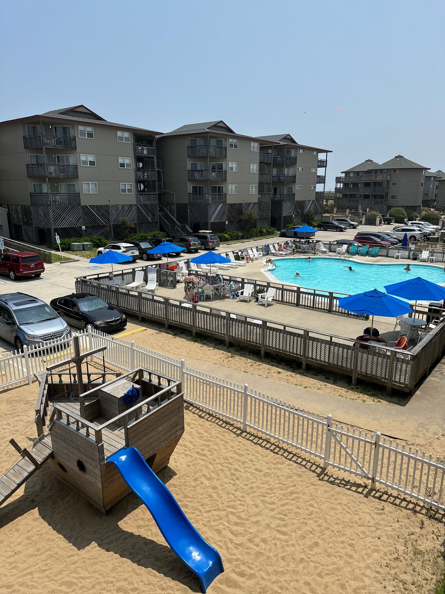 A pool area with a slide, lounge chairs, and umbrellas.