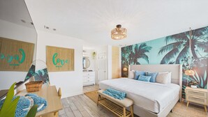 A bedroom with a large bed, a wall mural, a wooden bench, and a small table with a basket.