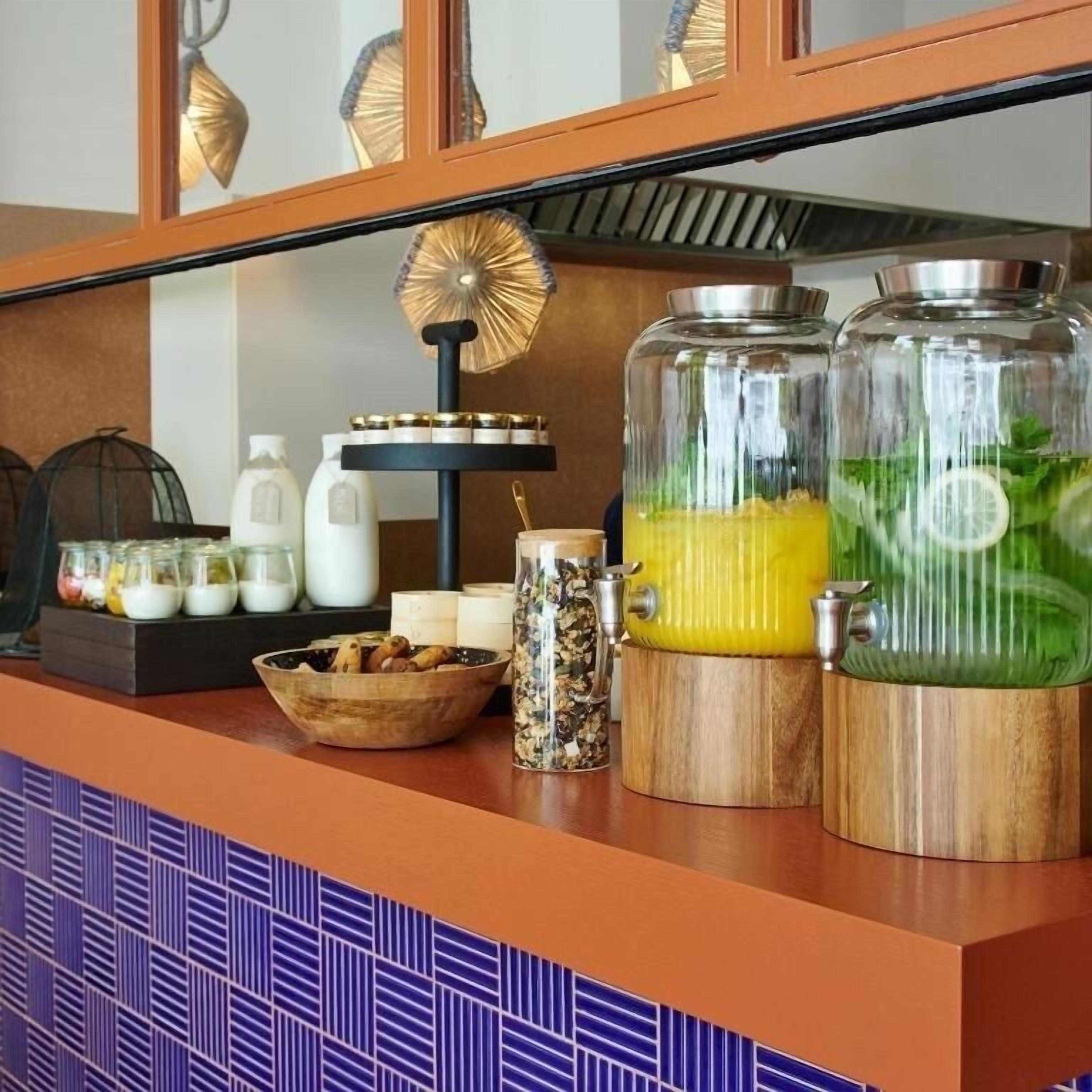 A kitchen counter with glass jars containing food items, a wooden bowl, and a decorative fan.