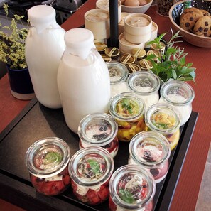A tray with various food items, including jars of pickled vegetables and cookies. - Loom Athens (Athens)