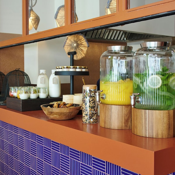 A breakfast bar with jars of condiments, a bowl of cookies, and a coffee machine. - Loom Athens (Athens)