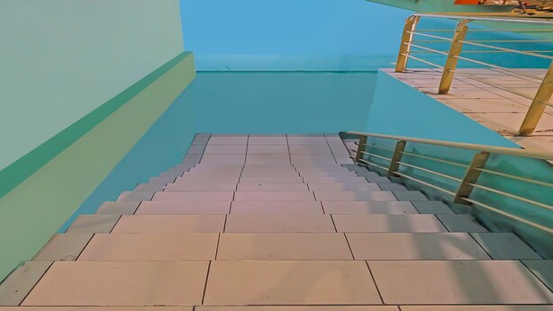 A staircase with metal railings and tiled steps leading to a higher floor. - Hotel O Hasan House Syariah 2NearVihara Budhi Bhakti (Batam)