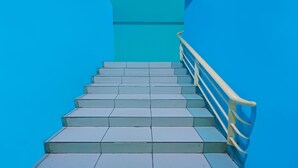 A staircase with blue walls and a white railing. - Hotel O Hasan House Syariah 2NearVihara Budhi Bhakti (Batam)