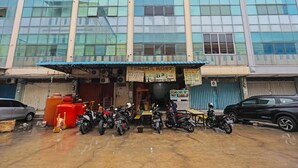 A building with multiple motorcycles parked in front. - Hotel O Hasan House Syariah 2NearVihara Budhi Bhakti (Batam)