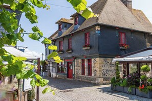 Ein historisches Gebäude mit einer Steinfassade, roten Türen und einer gepflasterten Straße.