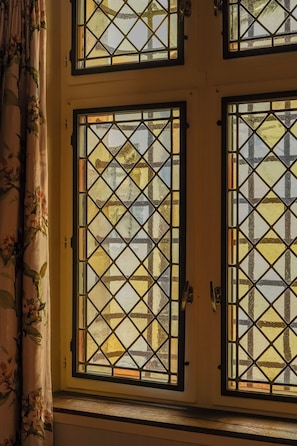 A room with a window featuring a diamond-patterned design. - L'Absinthe Hôtel (Honfleur)