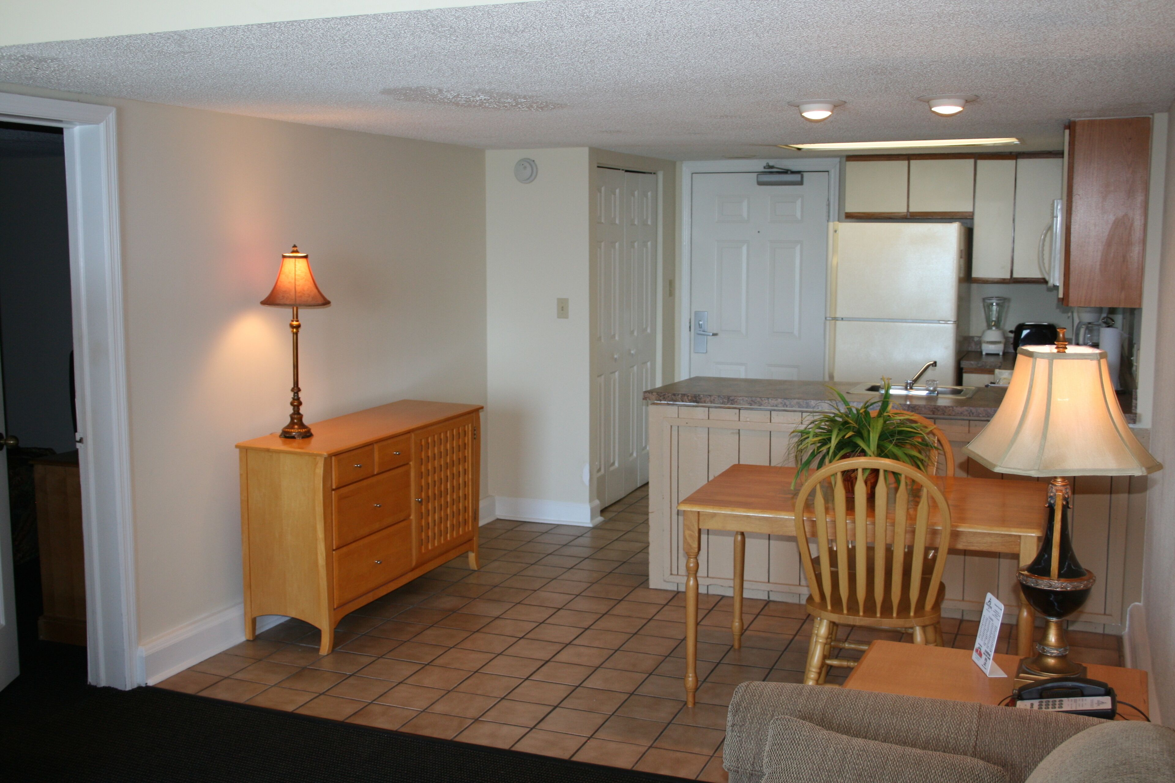 A compact living space with a dining area, kitchenette, and a small seating area.