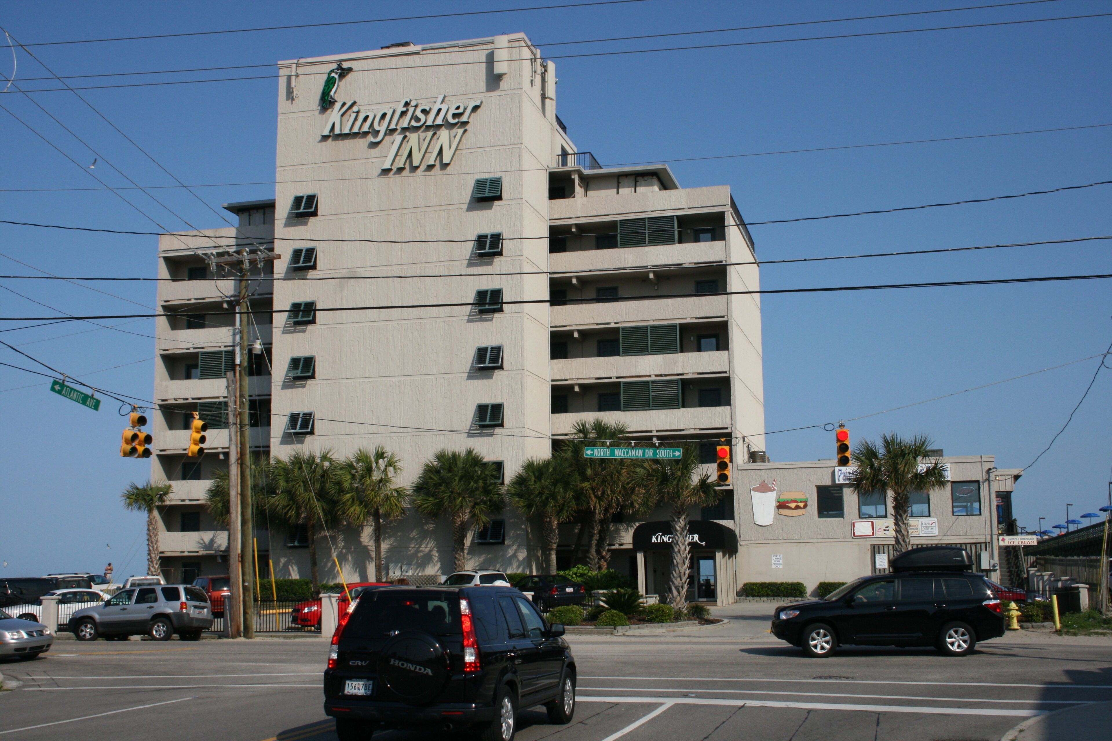A Kingfisher Inn building with multiple floors, air conditioning units, and a sign for 'North MacArthur St.'