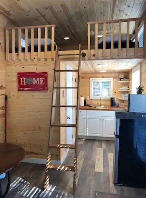 Cozy kitchen with a rustic feel, featuring a wooden ladder and a small table.