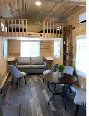 Relax in this inviting room with a loft area, sofa, armchairs, and a round table.