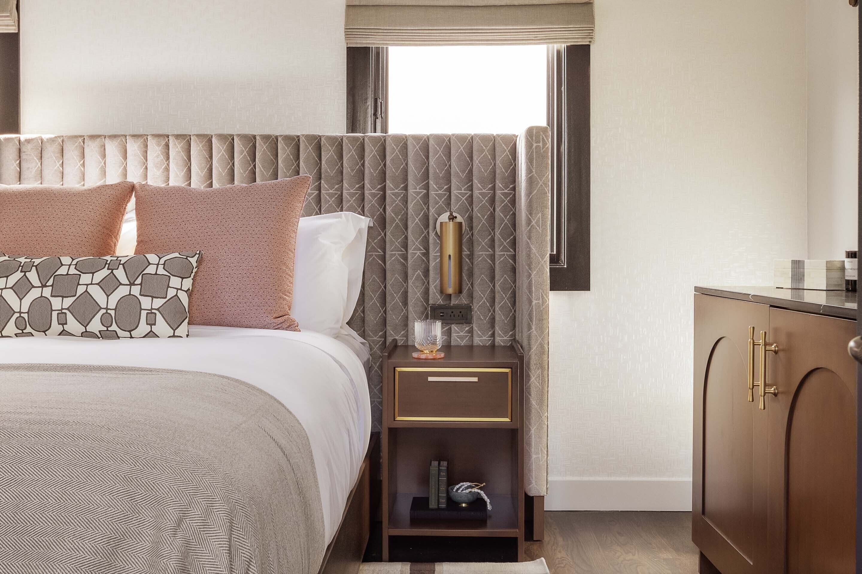 Habitación de hotel ordenada con cama, mesita de noche y armario.