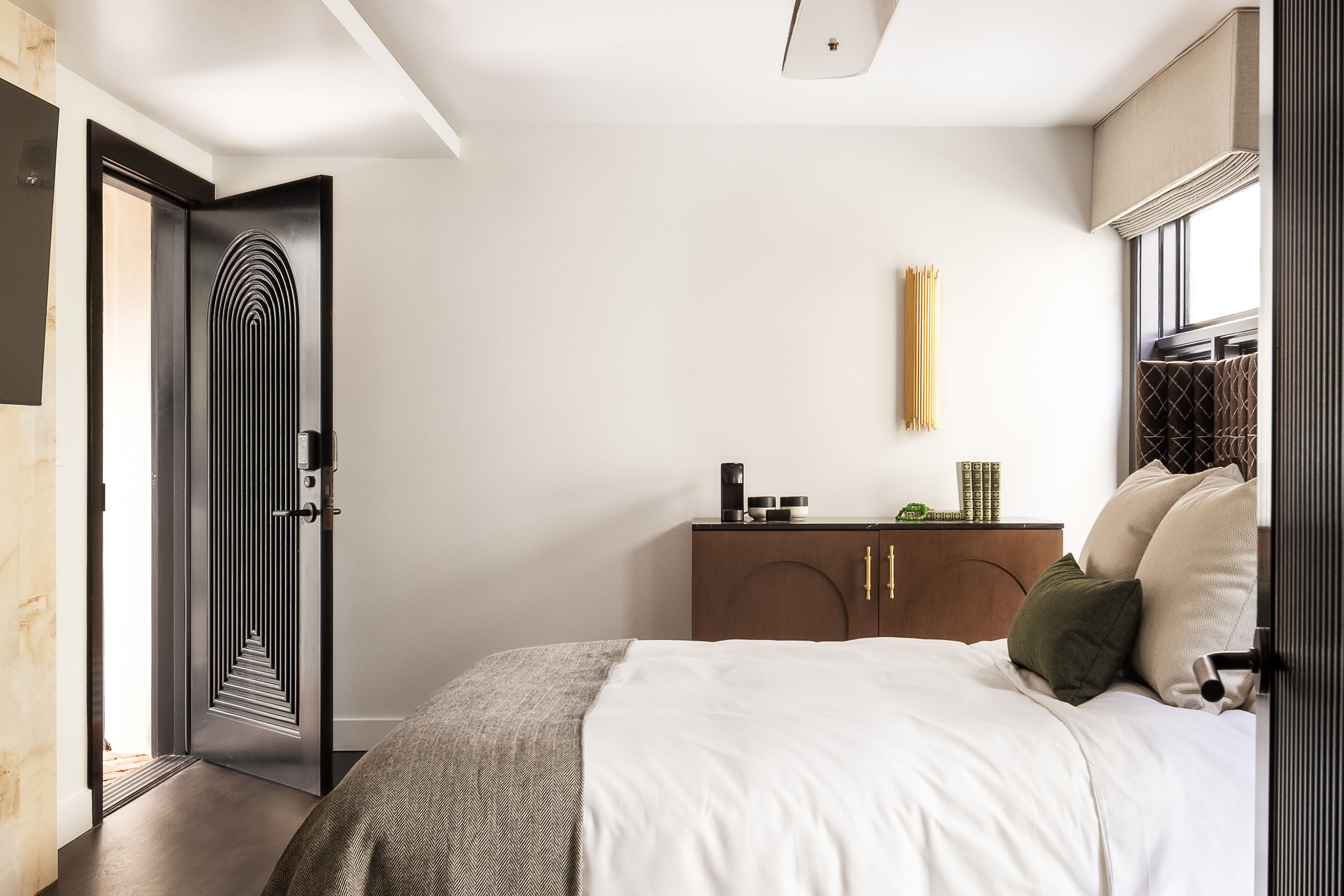 Une chambre à coucher avec un lit, une armoire, une table de chevet et une porte.