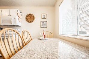 A kitchen with white cabinets, a microwave, a wooden clock, and two framed inspirational quotes on the wall. - ❤Cozy in the Springs! 2 BR, Kitchen. 4 Guests!❤ (Colorado Springs)