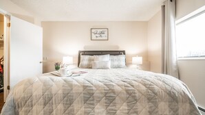 A neatly made bed with a quilted blanket, two bedside lamps, and a framed inspirational quote on the wall. - ❤Cozy in the Springs! 2 BR, Kitchen. 4 Guests!❤ (Colorado Springs)
