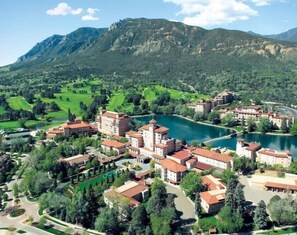 Un resort con varias edificaciones, un lago y vegetación circundante.