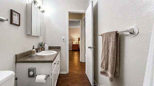 Een kleine badkamer met een wastafel, toilet en handdoekhouder.