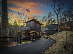 Une cabane avec un toit en pente, une véranda et une enseigne indiquant qu’il s’agit de la cabane « Na’cho Average ».