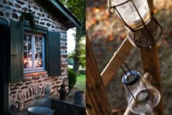 A stone building with a window and a hanging lantern. - Château de Riverie (Riverie)