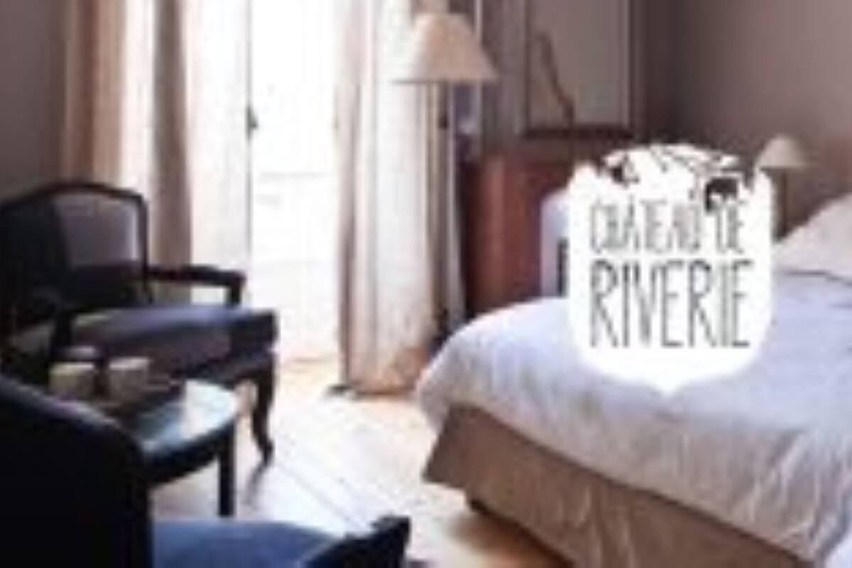 Een slaapkamer met een groot bed, een stoel en een nachtkastje.