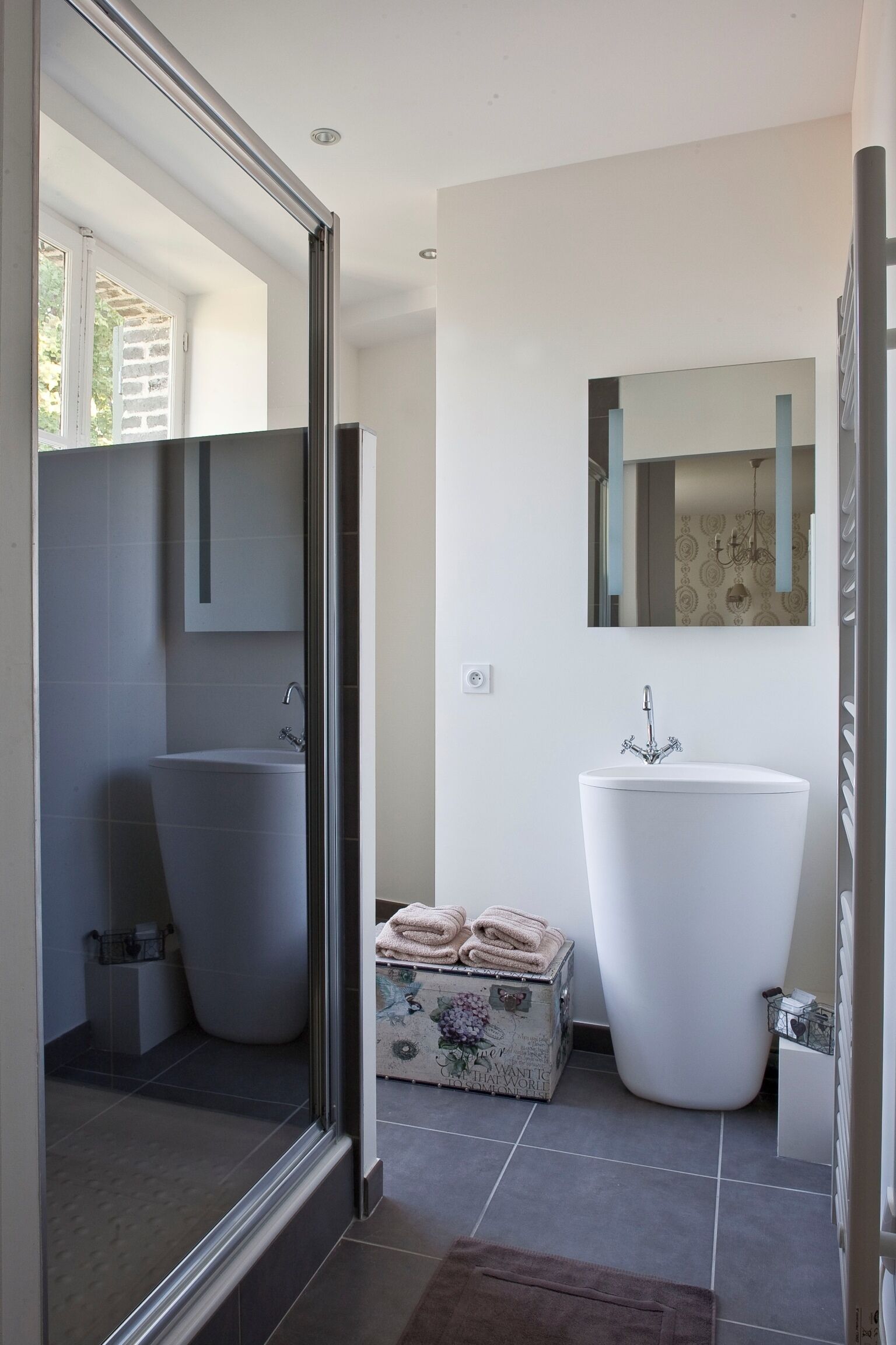 Une salle de bain moderne dotée d’une grande baignoire, d’une douche séparée et d’un meuble-lavabo avec un miroir.
