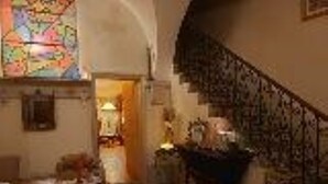 Ein gemütliches Interieur mit einer Treppe, einem Buntglasfenster und einem Kamin.