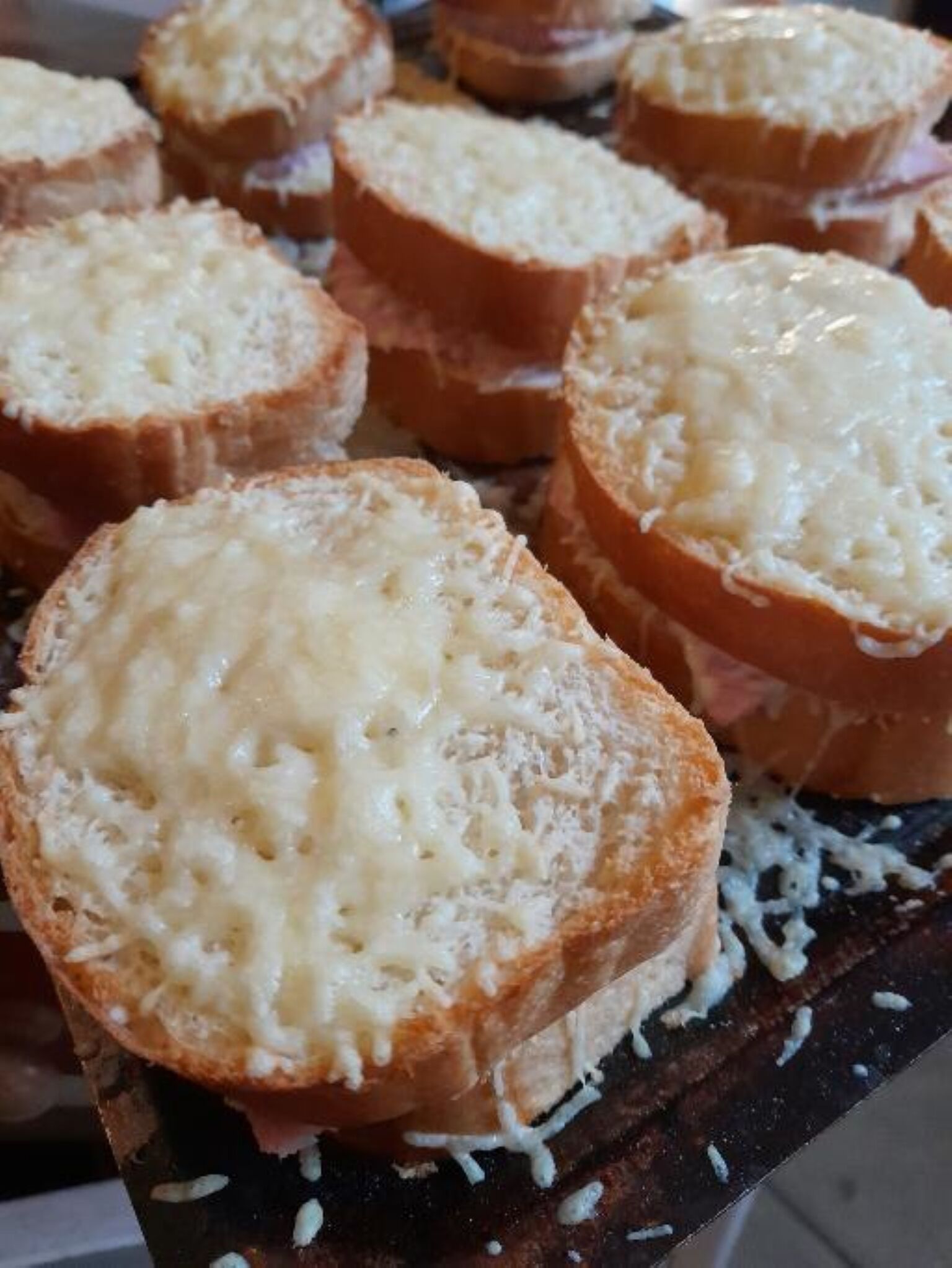 Mehrere Brotscheiben mit Käse belegt.