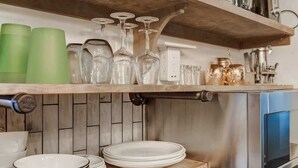 A kitchen with a wooden shelf holding glassware and a stainless steel oven. - Come to the Hideout! Hot Tub, Fire Pits & Views! (Woodland Park)