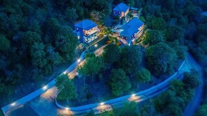 An aerial view of a residential area with multiple houses surrounded by dense forest.