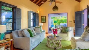 A living room with a sofa, armchairs, a coffee table, and a dining area with chairs.