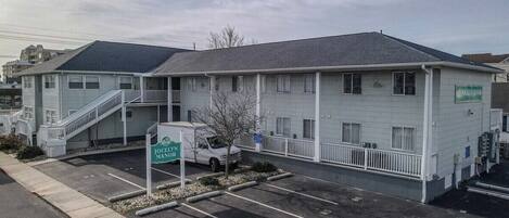 Ein Motel mit Parkplatz, Treppe und einem Schild mit der Aufschrift 'Jocelyn Manor'.