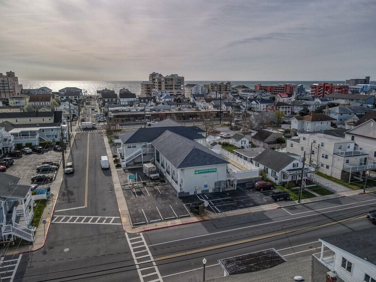 A coastal town with a prominent building labeled "JOLLY MANOR" in the center, surrounded by residential houses and a wide street.
